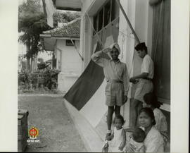 Pemuda Indonesia sedang mengibarkan bendera merah putih setelah penyerahan kedaulatan RI.