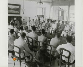 Presiden Soekarno sedang mendengarkan pembicaraan dari salah satu Anggota KNIP dan diperhatikan o...